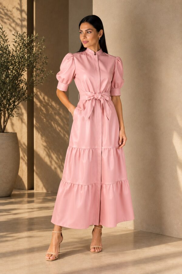 Vestido de couro rosa pastel com mangas bufantes, gola padre, abotoamento frontal, faixa com laço na cintura e saia em camadas
